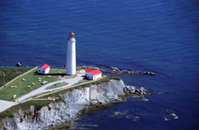Arial view of the Lighttower at Cap-des-Rosiers putting into evidence its visual prominence owing to its location at the edge of a cliff, its simple, elegant design, massive scale and colour, which all contribute to its soaring, white silhouette, 2001 © Parks Canada Agency/Agence Parcs Canada, J.F. Bergeron, 2001.