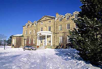 General view of the Old Government House National Historic Site of Canada showing the pedimented projecting frontispiece with semi-circular portico over the main entry, 1995. © Parks Canada Agency / Agence Parcs Canada, J. Butterill, 1995.