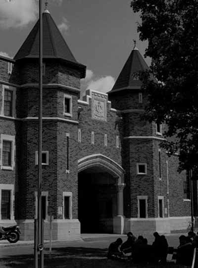 View of main entrance to Salaberry Armoury, showing the red brick and white limestone exterior with the central arched main entrance flanked by round towers, 1989. © Parks Canada Agency / Agence Parcs Canada, Henri Langlois, 1989.