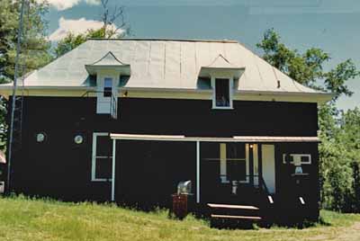 View of Wabenaki Lodge, showing the verandah attached to the northeastern façade, 1990. © Canadian Parks Services / Service canadien des parcs, 1990.
