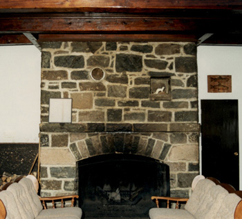 Interior view of Wabenaki Lodge, showing the quarry stone fireplace, 1990. © Canadian Parks Services / Service canadien des parcs, 1990.