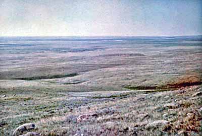 Vue générale du cairn du British Block, qui montre son emplacement dans une région de prairie vallonnée des grandes plaines, couverte de végétation mixte. © Parks Canada Agency / Agence Parcs Canada, Harry A. Tatro.