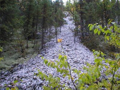 Vue générale de la carrière Rogers du site Waapushukamikw qui se retrouve à être la source de quartzite de Mistassini la plus visible et la plus facilement accessible, 2004. © ministère du Développement durable, de l’Environnement et des Parcs du Québec, J. Gagnon, 2004.