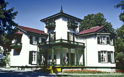 General view of Bellevue House showing the original Italianate proportions of its silhouette with a high square tower, balconies and a columned verandah, 1985. © Parks Canada Agency / Agence Parcs Canada, B Morin, 1985.