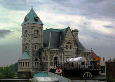 General view of the Former Galt Post Office, showing the imposing side tower with a clock and pyramidal roof. © Parks Canada | Parcs Canada, 1989