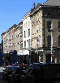 View of Granville Block, showing the similar four to five storey massings of the buildings with stone and brick façades, 2005. © Parks Canada Agency / Agence Parcs Canada