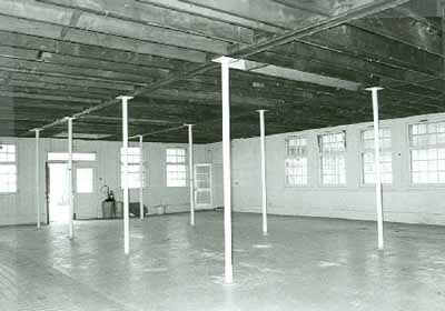 Interior view of the Small Dairy Barn, showing the parged concrete foundation, 1987. © Parks Canada Agency / Agence Parcs Canada, 1987.