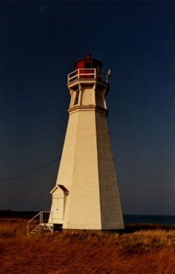 Vue en angle de l'arrière du phare de Cape Jourimain montrant la structure, la hauteur et les proportions équilibrées d’origine du bâtiment, 1990 © Transport Canada | Transports Canada