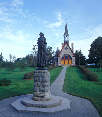 Vue générale de Grand-Pré, qui montre la chapelle commémorative, qui imite le style des anciennes constructions québécoises , 2007. © Parks Canada Agency / Agence Parcs Canada.