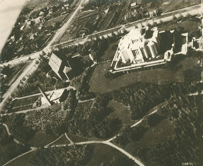 Aerial view of the Temple of the Church of Jesus Christ of Latter Day Saints, showings its siting in the midst of a landscaped square with a surrounding stone wall separating it from the surrounding town, 1926. © Department of Energy, Mines and Resources / Ministère de l'Énergie, des Mines et des Ressources, 1926.