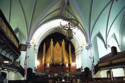 View of the interior of St. James United Church emphasizing the surviving original interior features at the north end of the sanctuary which typify Methodist churches of the period, including the communion rail, the pulpit platform, the pews for the choir © Parks Canada Agency / Agence Parcs Canada, D. Stiebeling