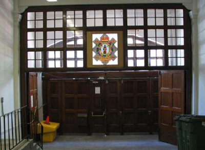 Vue intérieure du manège militaire, qui montre l’ancien emblème héraldique des armoiries du régiment arborant un sanglier au-dessus de l’entrée principale, 2006. © R. Goodspeed, 2006.