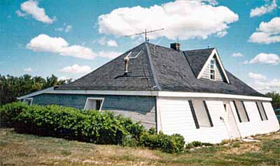 General view of the Addison Sod House, showing its low one-and-a-half-storey, pyramidal massing set under a hipped roof. (© Parks Canada | Parcs Canada)