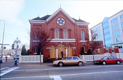 View of the exterior of the Congregation Emanu-el Temple, showing the circular window in the pedimented gable, 1994. © Parks Canada Agency / Agence Parcs Canada, J. Butterill, 1994.