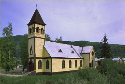 General view of St. Paul's Anglican Church, showing the rectangular massing under a steep gabled roof with truncated transepts, polygonal apse, and  tower with pyramidal, bell-cast roof. (© Parks Canada Agency / Agence Parcs Canada.)