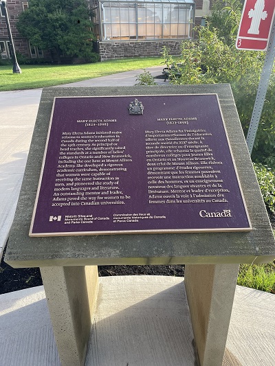Mary Electa Adams plaque installed right in front of the fire hydrant, in front of the Flemington Building at 63B York St., Mount Allison Campus © Parks Canada Agency / Agence Parcs Canada, 2023