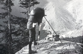 black and white photo of man photographing glacier