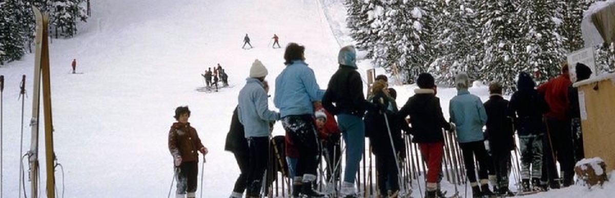 Vue de la pente de l’ancienne station de ski sur le sentier de la Tally-Ho, avec des skieurs et la file d’attente au remonte-pente.
