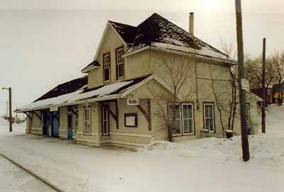 Vue en angle de l'ancienne gare du Chemin de fer Canadien du Nord, montrant les façades du devant et du côté, 1991. (© Parks Canada Agency/Agence Parcs Canada, Murray Peterson, 1991.)