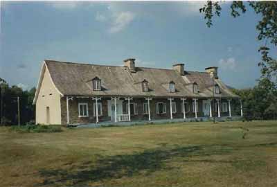 View of the house, showing the building’s basic massing and construction technology, representative of the early architecture of New France, 1991. © Agence Parcs Canada / Parks Canada Agency, 1991.