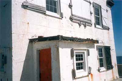 Vue détaillée où l'on peut apervecoir la forme, le volume et les proportions de ce simple bâtiment de deux étages et demi coiffé d’un toit à pignon avec un avant-toit à rebord, 1999. © Canadian Coast Guard / Garde côtière canadienne, 1999.