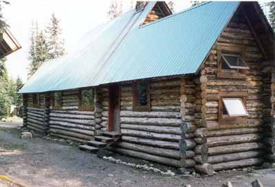 Rear elevation of the Stanley Mitchell Alpine Hut, showing the horizontally laid, peeled round logs with saddle-notched corners, 1998. © Parks Canada Agency/Agence Parcs Canada, 1998.