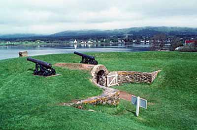 General view of the Black Hole Powder Magazine showing the mounded earth cover and the curved revetment walls of rubble stone, 1994. © Parks Canada Agency / Agence Parcs Canada, J.P. Jérôme, 1994.