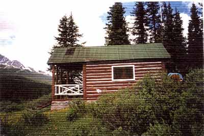 Side elevation of Medicine Tent Warden Cabin, showing the gabled roof with generous overhangs, 1996. © Parks Canada Agency / Agence Parcs Canada, 1996.