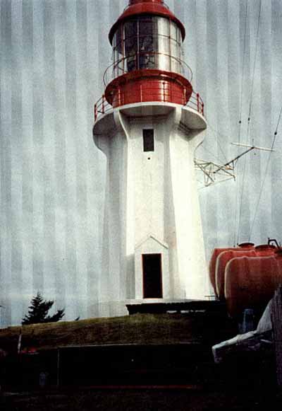 Vue de la façade du phare de l'île Langara, où l'on peut apercevoir le fronton en saillie de la porte, et la construction en béton à surface lisse, 1994. © Canadian Coast Guard / Garde côtière canadienne, 1994