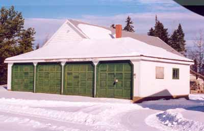 Corner view of the Four Car Garage, showing the front and side façades, 1996. (© Canadian Forest Service/Service canadien des forêts, 1996.)