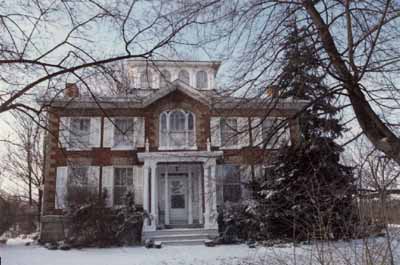View of the main façade of Bentley House, showing the centre door accentuated by a delicate porch, supported by delicate Italian colonnettes, 1992. © Public Works and Government Services Canada / Travaux publics et Services gouvernementaux Canada, 1992.