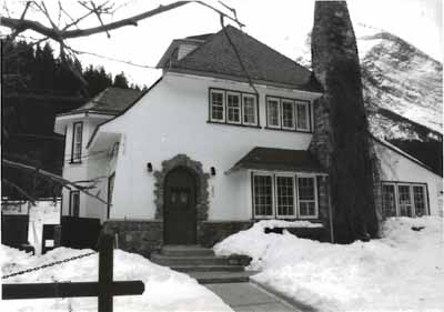 Front elevation of the Superintendent's Residence, showing the combination of rough-finished stucco with woodwork and stone, ca. 1991. © Agence Parcs Canada / Parks Canada Agency, ca./vers 1991.