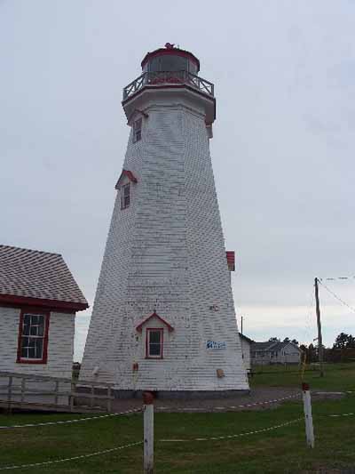 Vue de l'extérieur du phare, qui montre la charpente en lourdes poutres revêtue de bardeaux de bois peintes, 2009. © Parks Canada Agency / Agence Parcs Canada, Jamie Mitchell, 2009.
