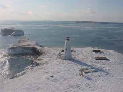 Aerial view of the Flint Island Lighthouse against a winter's day backdrop. © Department of Fisheries & Oceans Canada/Département de pêches et océans Canada, n.d.