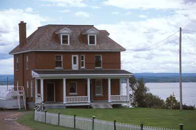 View of Building 67, showing the two-and-a-half-storey, cubic-shaped massing with truncated hipped roof, circa 2004. (© Agence Parcs Canada / Parks Canada Agency, circa / vers 2004.)