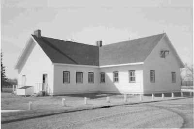 Side elevation of the Barracks No. 5, showing the simple, single-storey massing of the T-shaped building, 1989. © Agence Parcs Canada / Parks Canada Agency, 1989.