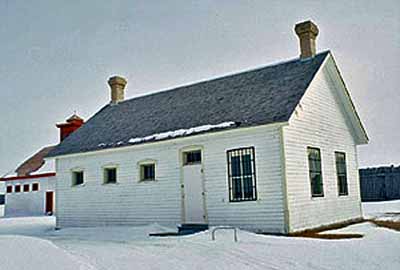 General view of the Guard House, showing the spacing of the door and window openings, the multi-paned windows and the steel bars over some of the windows, 1991. © Agence Parcs Canada / Parks Canada Agency, D. McArthur, 1991.