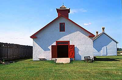 Front facade of the Sick Horse Stable, showing the large double doors and the small high windows for the horses, 2003. © Parks Canada Agency / Agence Parcs Canada, M. Fieguth, 2003.