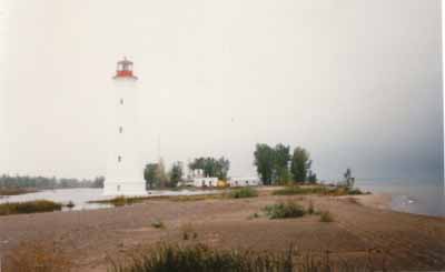 General view of the Light Tower, showing the white-painted exterior and the red-painted lantern, 1986. © Canadian Coast Guard / Garde côtière canadienne, 1986.