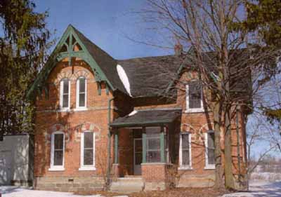View of the main entrance of Former Miller Residence, showing the well-proportioned composition of its main façade, which features narrow windows, a single roof dormer, and a main entry porch, 2005. © Department of Public Works and Government Services / Ministère des Travaux publics et services gouvernementaux, 2005.