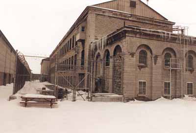 Vue de l'atelier est, qui montre le volume sur trois étages avec un toit à deux versants en pente moyenne, 1989. © Travaux publics Canada / Public Works Canada, 1989.