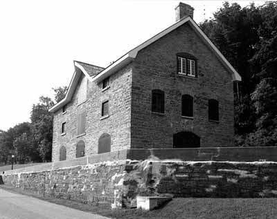 Corner view of the Commissariat Building, showing the fenestration pattern on the north elevation, which illustrates its original administrative and residential functions, 1989. © Parks Canada Agency / Agence Parcs Canada, Couture, 1989.