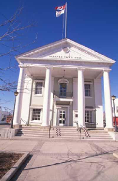 View of Napanee Town Hall, showing its two-storey, gable-roofed massing with a monumental pedimented portico with giant free-standing columns approached up broad steps, 1995. © Agence Parcs Canada / Parks Canada Agency, 1995.