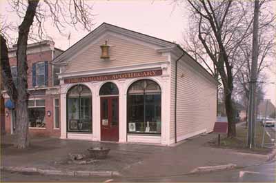 Vue en angle montant deux façades du lieu historique national du Canada de la Pharmacie-de-Niagara, 1990. (© Parks Canada Agency / Agence Parcs Canada, 1990.)