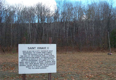 Vue rapprochée du panneau d'interprétation de la mission de Saint-Ignace II de la ferme Hamilton, 2004. © Agence Parcs Canada / Parks Canada Agency, J. Molnar, 2004.