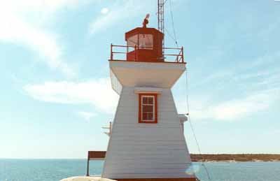 General view of the Tower, showing the square walkway with guardrail and prominent octagonal lantern, 1990. © Canadian Coast Guard / Garde côtière canadienne, 1990.