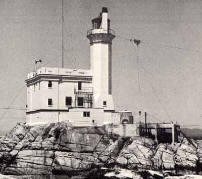 General view of Triple Island Lighthouse, showing the clean lines, and subtle ornamentation, including the decorative brackets supporting the platform surmounted by an iron lantern. (© Parks Canada Agency / Agence Parcs Canada.)