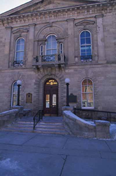 Exterior view of Guelph City Hall, showing its Italianate detailing, including a central, Venetian window, ornamental balconies, a string course delineating stories, 1995. © Parks Canada Agency/Agence Parcs Canada, J. Butterill, 1995.