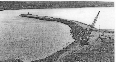 View of the rock-fill causeway under construction, advancing towards the Cape Breton Shore, summer 1953 © Canso Causeway 50th Anniversary Picture Gallery, http:www.cansocauseway/ca.pictures.htm
