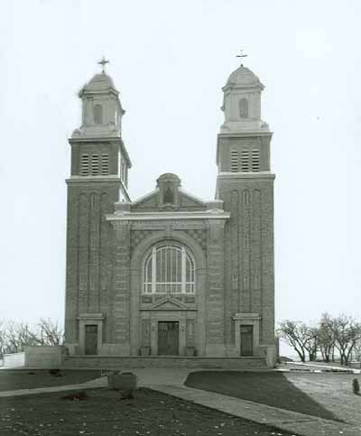 Front elevation of the Cathedral of Our Lady of the Assumption, part of the Gravelbourg Ecclesiastical Buildings National Historic Site of Canada, showing its twin towers crowned by cupolas. © Parks Canada Agency / Agence Parcs Canada
